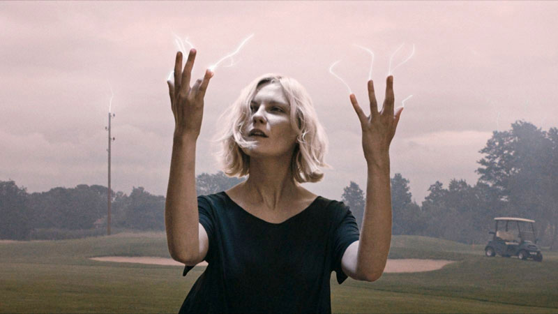 Kirsten Dunst from 'Melancholia' looking at her hands as electricity flows out of her fingers