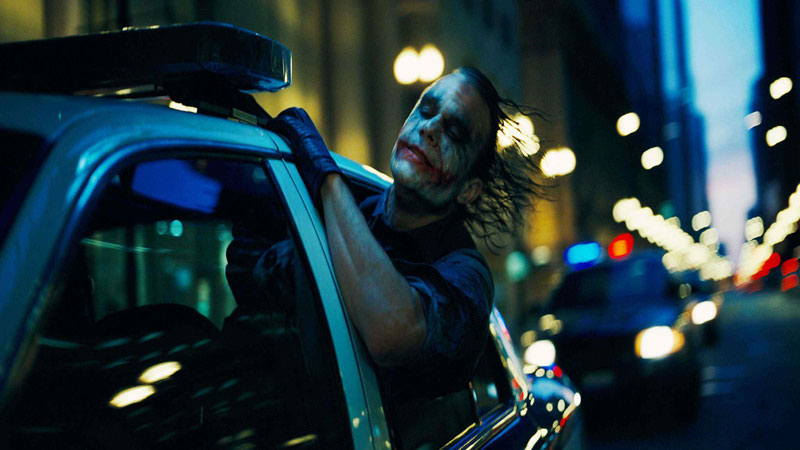 The Joker from 'The Dark Knight' feeling the wind on his face out of a police patrol car window