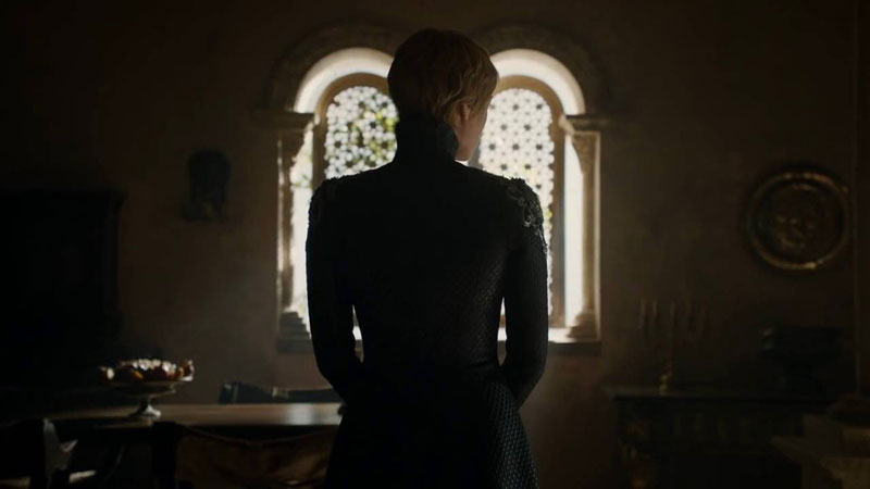 An actress from 'Game of Thrones' on HBO looking away in a dark outfit with a shining window