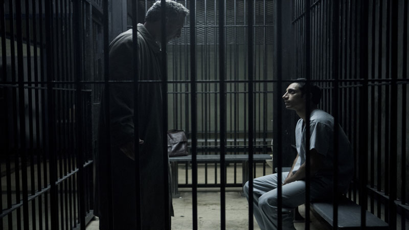 Two of the actors from 'The Night Of' in a jail cell with one towering over the other